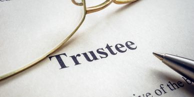 Trustee document with glasses and pen
